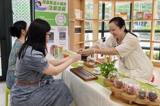 顺来茶业茶艺师现场展示茉莉花茶文化，与市场亲切互动。文樟梅摄